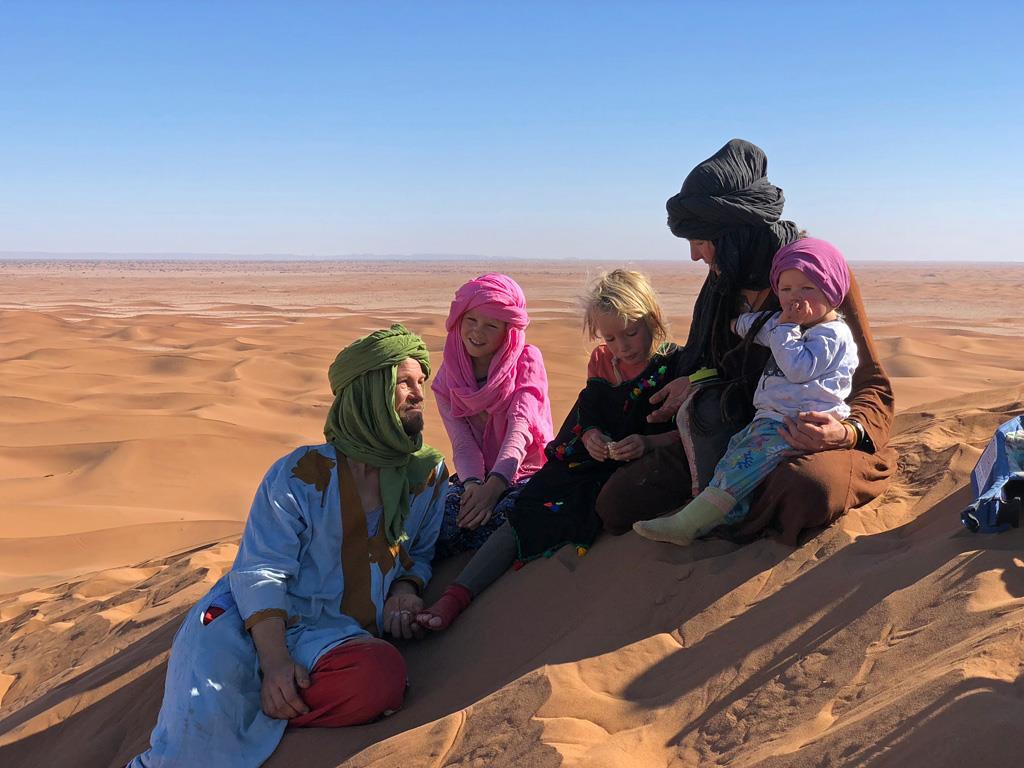 Desert bivouac camp at sunset with tents and campfire